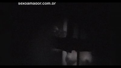 Blondie se fait secrètement filmer par un voyeur du quartier caché derrière des briques creuses.